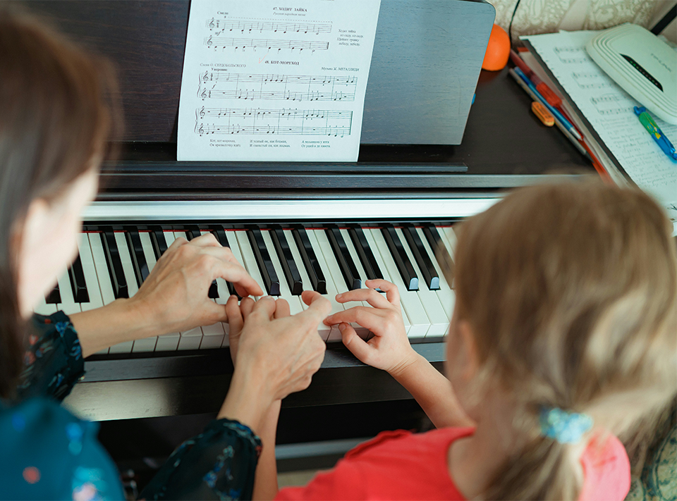 Music therapy with therapist and child at piano
