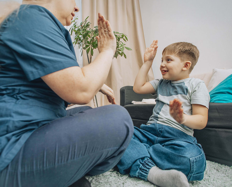 Boy in ABA therapy giving therapist a high five